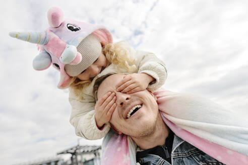 Happy daughter covering father's eyes under cloudy sky - SIF00691
