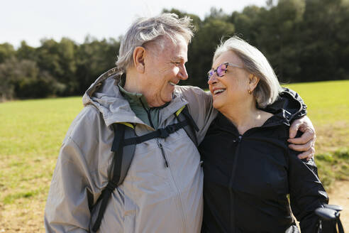 Affectionate senior couple standing in nature with arm around - EBSF03065