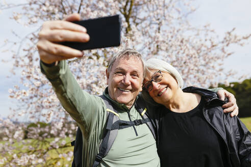 Älteres Paar, das an einem hellen und sonnigen Tag mit seinem Smartphone einen süßen Moment mit einem Selfie festhält - EBSF03070