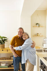 Zärtliches älteres Paar umarmt sich in der Küche - EBSF03106