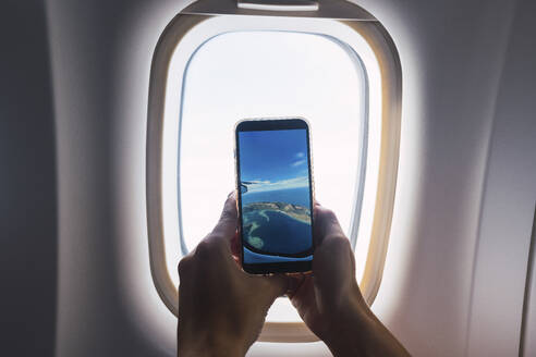 Mann fotografiert durch ein Flugzeugfenster - PNAF05157