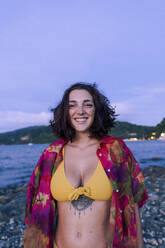 Happy young woman enjoying on beach at dusk - PNAF05198