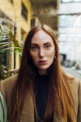 Redhead woman standing in front of building - MEUF09060