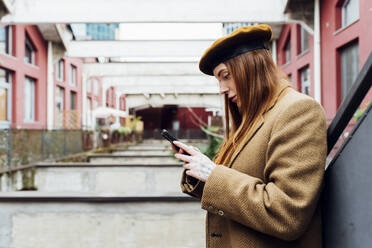 Woman using smart phone outside building - MEUF09072