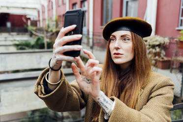 Redhead woman taking selfie through smart phone - MEUF09074