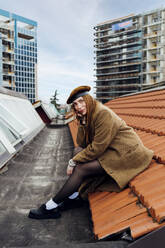 Fashionable woman sitting on rooftop - MEUF09081