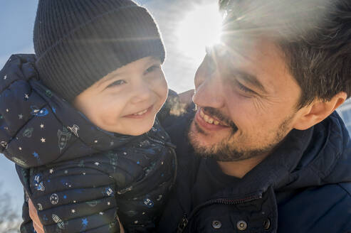 Glücklicher Vater mit süßem Sohn an einem sonnigen Tag - ANAF01141