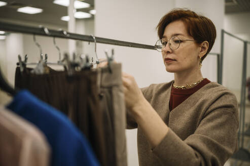 Frau mit Brille arbeitet in einem Bekleidungsgeschäft - ANAF01159