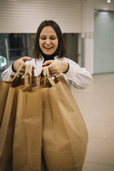 Glückliche Frau mit Einkaufstüten - ANAF01162