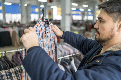 Mann sieht sich Kleidung im Geschäft an - ANAF01167