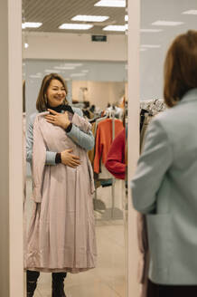 Glückliche Frau mit Kleid im Spiegel - ANAF01178