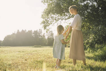 Mother and daughter standing in nature on sunny day - NDEF00432