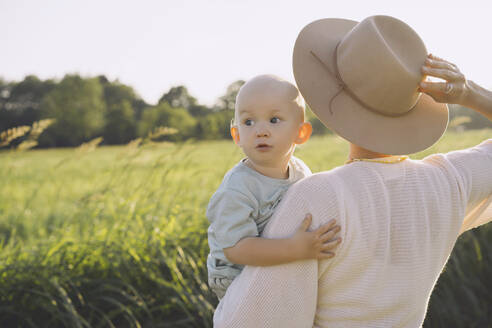 Mutter mit Hut und Sohn in der Natur an einem sonnigen Tag - NDEF00445