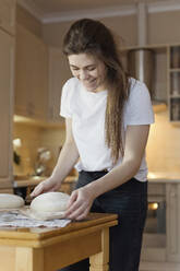 Glückliche Frau beim Brotbacken zu Hause - ONAF00463