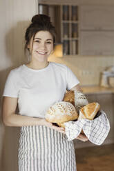 Glückliche Frau mit frischem Brot in der Hand - ONAF00478