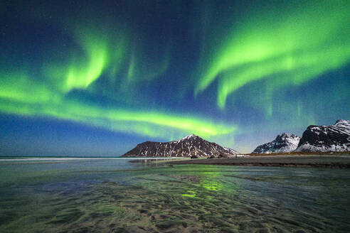 Skagsanden Strand unter dem hellen Nordlicht (Aurora Borealis) Himmel, der sich im Meer spiegelt, Ramberg, Nordland, Lofoten, Norwegen, Skandinavien, Europa - RHPLF23671