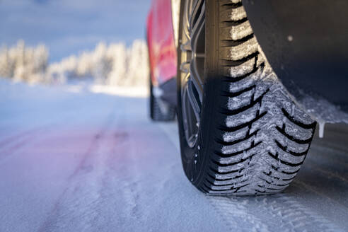 Winterreifen eines Autos auf rutschiger Straße im verschneiten Wald, Kangos, Landkreis Norrbotten, Lappland, Schweden, Skandinavien, Europa - RHPLF23775