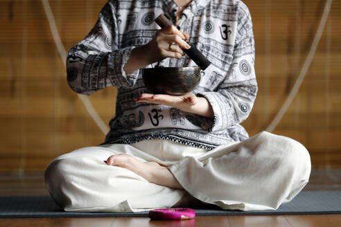 Tibetische Schale, buddhistische Frau beim Üben einer Klangschale für die Klangtherapie in einer Atmosphäre für Heilung, Meditation, Yoga und Entspannung, Quang Ninh, Vietnam, Indochina, Südostasien, Asien - RHPLF23912