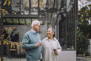 Male and female retired friends talking to each other at dinner party - MASF36250