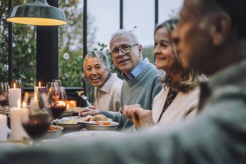 Männliche und weibliche ältere Freunde beim Essen auf einer Dinnerparty - MASF36284