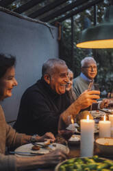 Glücklicher reifer Mann genießt mit Freunden im Ruhestand während einer Dinnerparty - MASF36301
