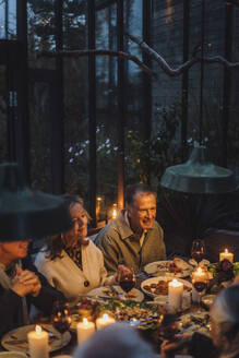 Glückliche ältere männliche und weibliche Freunde beim Essen auf einer Dinnerparty - MASF36306