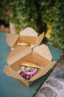 Freshly prepared burgers in take away boxes on table at restaurant - MASF36335