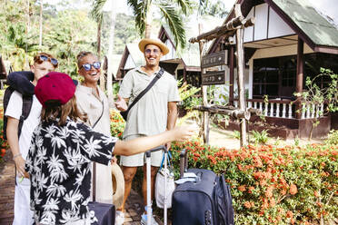 Glückliche Familie mit Gepäck bei der Ankunft am Urlaubsort während des Urlaubs - MASF36538