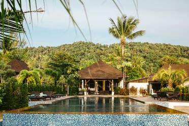 Schwimmbad außerhalb der Villa durch grüne Bäume gegen den Himmel im Resort - MASF36575