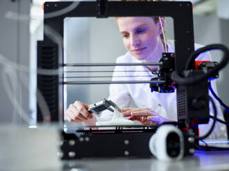 Engineer using vernier calliper operating on 3D printing machine - CVF02367