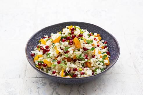 Bowl of cauliflower salad with pomegranate seeds, pistachios, mint, parsley and dried apricot - LVF09316