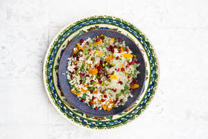 Schüssel Blumenkohlsalat mit Granatapfelkernen, Pistazien, Minze, Petersilie und getrockneten Aprikosen - LVF09317