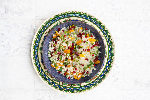 Bowl of cauliflower salad with pomegranate seeds, pistachios, mint, parsley and dried apricot - LVF09317