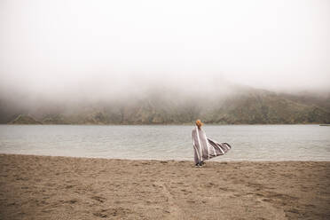 Frau mit Poncho steht vor einem See - PCLF00364