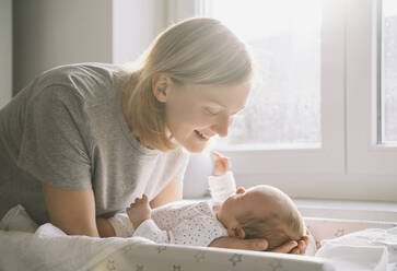 Happy mother taking care of baby boy at home - NDEF00470