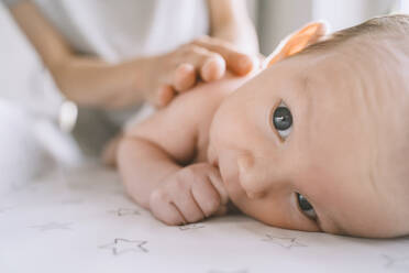 Mother changing diaper of baby boy on changing table - NDEF00475