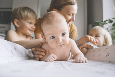 Mutter mit Kindern kümmert sich zu Hause um einen kleinen Jungen - NDEF00482