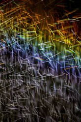 Long exposure of spray of water covered in rainbow colored light - NDF01552