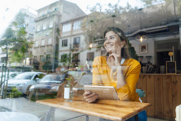 Glückliche Frau sitzt Tablet-PC durch Glas gesehen - JOSEF18278