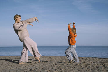 Sorglose Mutter und Tochter tanzen am Strand - NDEF00490