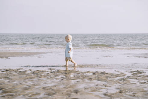 Junge mit blondem Haar genießt am Strand - NDEF00496