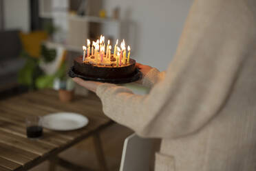 Woman holding birthday cake at home - JCCMF10165