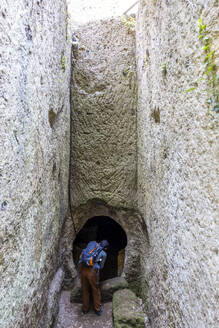 Älterer Mann mit Rucksack betritt Höhle, Toskana, Italien - MAMF02763