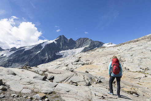 Frau mit Rucksack beim Wandern an einem sonnigen Tag, Kärnten, Österreich - FOF13687