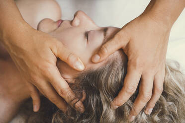 Hände eines Therapeuten bei der Kopfmassage eines Kunden in einem Friseursalon - NDEF00522