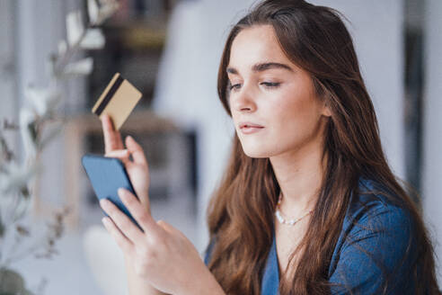 Young businesswoman making payment with credit card on smart phone - JOSEF18344