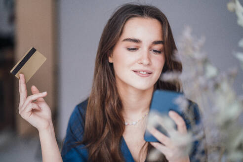 Businesswoman making payment with credit card on smart phone - JOSEF18345