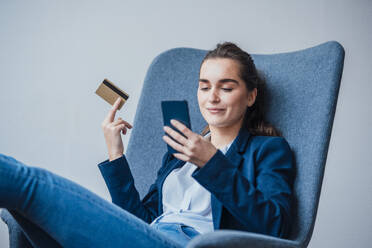 Young businesswoman with credit card using smart phone - JOSEF18393