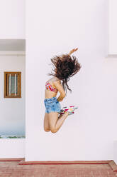 Unbekümmerte Frau springt vor die Wand - EGHF00741