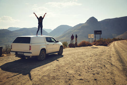 Friends exploring Cederberg Mountains from roadside on sunny day - KOF00047